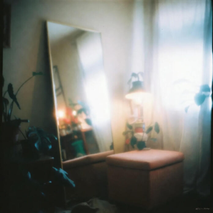 Cozy corner with mirror, ottoman, and soft light.